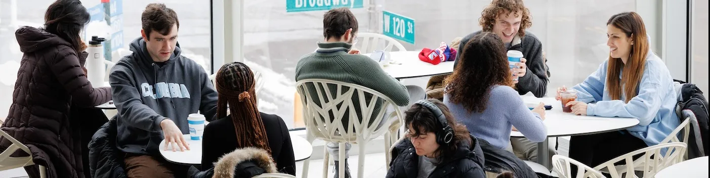 Students talking and having coffee at a cafe on Columbia University's Morningside campus
